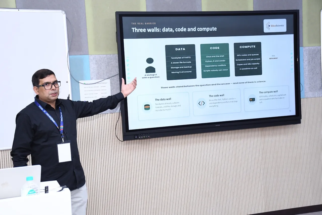An instructor presenting a slide on the three barriers that stand between a biologist and an answer: data, code and compute