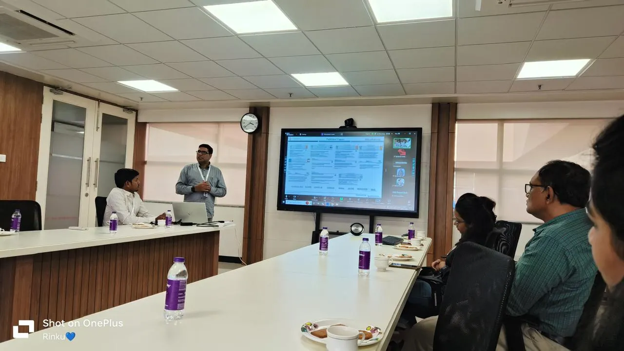 A scientist presenting published papers to a small research group around a table