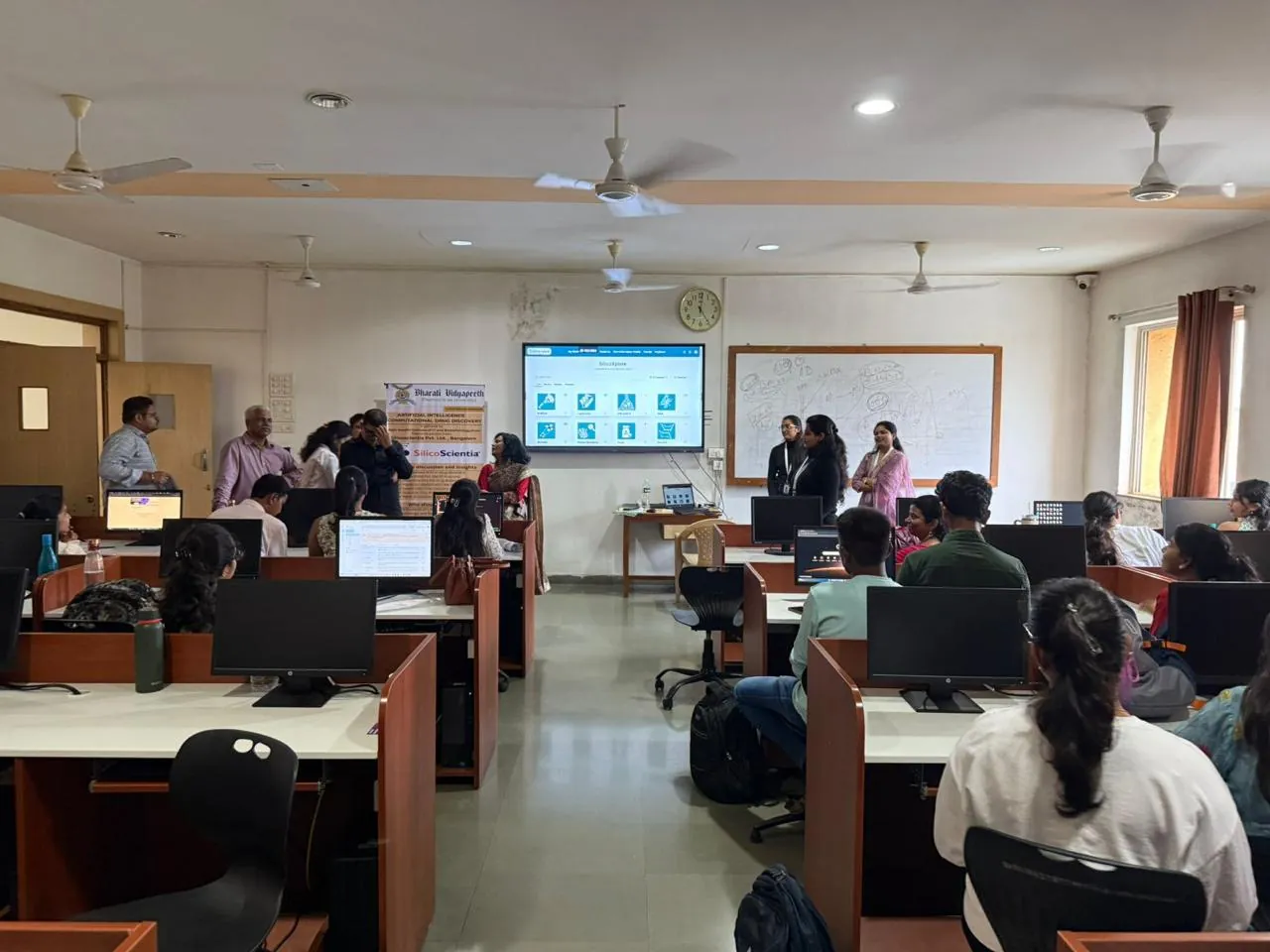 Participants in a computer laboratory following a SilicoXplore session on the wall screen
